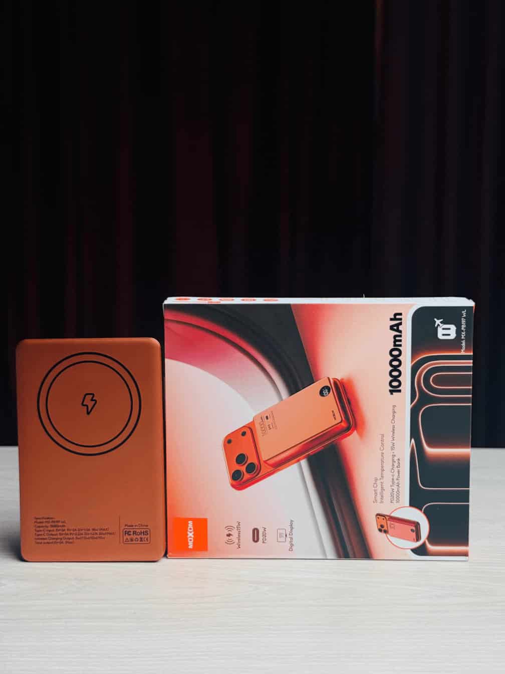 "MOXOM 10,000mAh wireless power bank with a matte finish, magnetic charging surface, and an LED display showing battery levels."